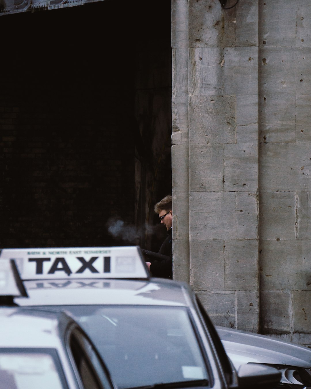man-in-black-jacket-standing-beside-car-during-daytime-e-zqnckqu3w